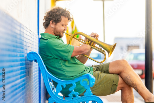 One-armed man playing trumpet on urban bench photo