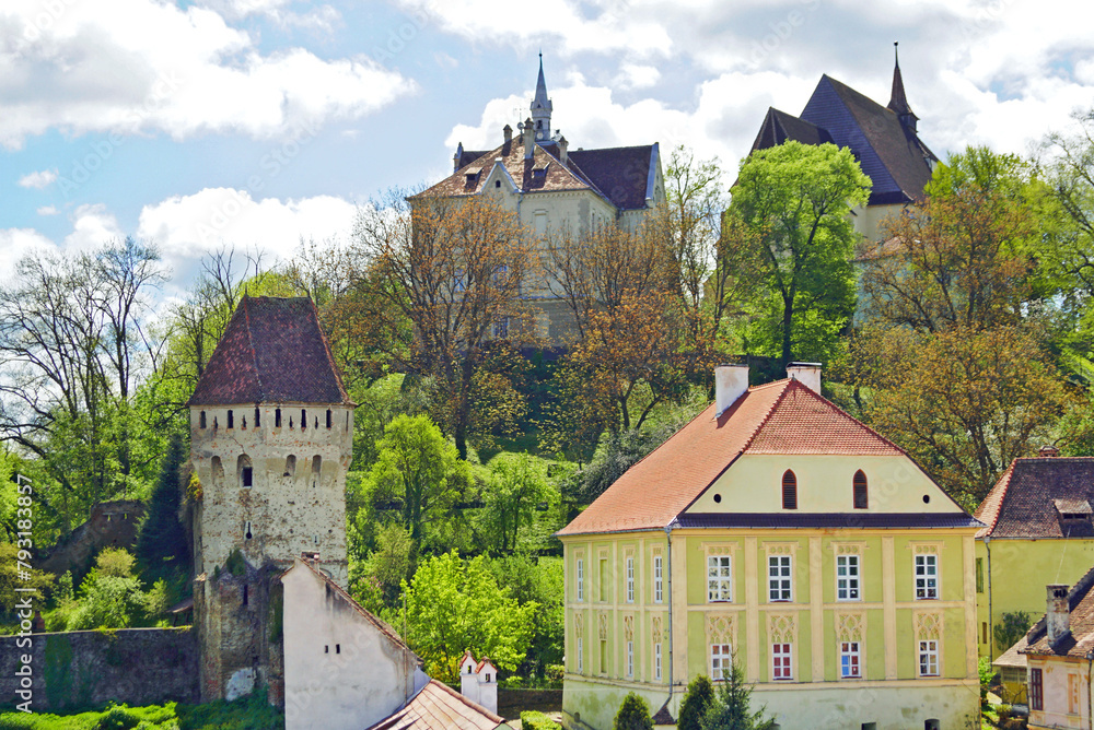 Fototapeta premium View of the architecture in the upper part of the Old Town of Sighisoara from the view of the Clock Tower: the Tinsmiths' Tower, the Church on the Hill, the old school and other buildings
