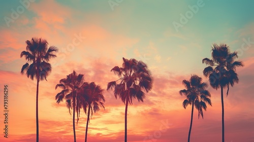 Soft pastel hues paint the sky as tropical palm trees stand tall in a peaceful sunset scene