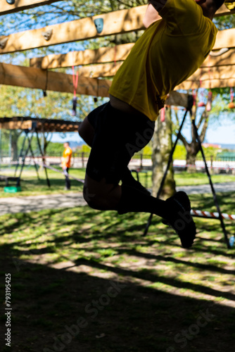 an athlete at a hanging obstacle at an obstacle course race, OCR