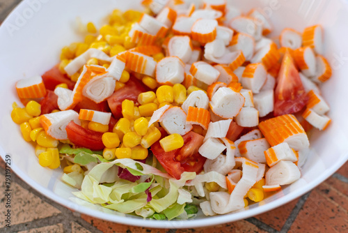 Obraz na płótnie Featuring crab sticks, sweet corn, and green lettuce, a colorful salad is elegantly presented on a white plate w salonie