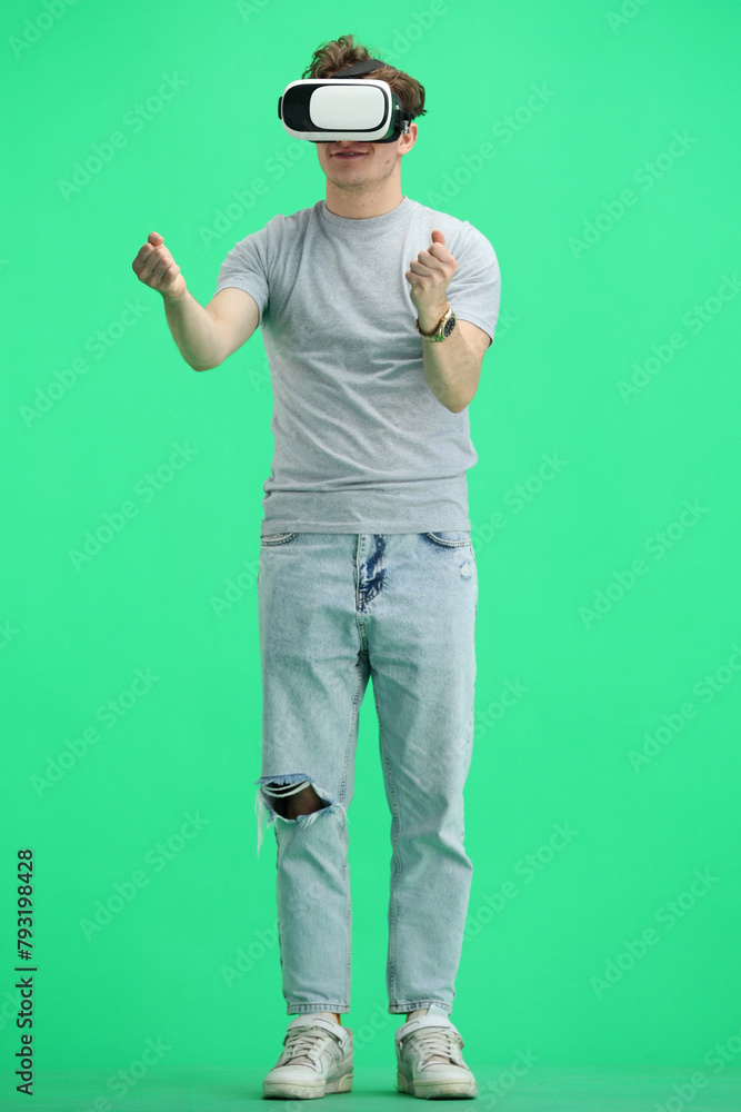 Man, full-length, on a green background, wearing VR glasses Man, full-length, on a green background, wearing VR glasses