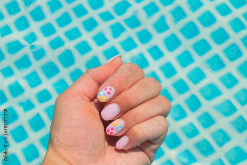 A woman swims in the pool. Female hand with manicure under clean water.