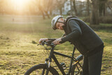 Senior Cyclist Checking Bicycle Before Riding in a Park