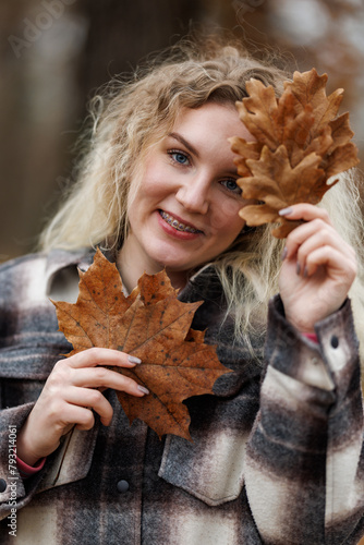 Portrait of a Woman Holding a Leaf and Smiling at Camera