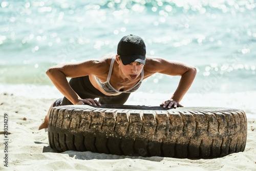 Woman Doing Push Ups on Tire on Beach