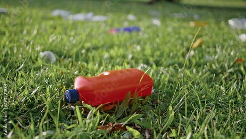 Plastic bottle lying discarded on grass highlighting pollution problem closeup
