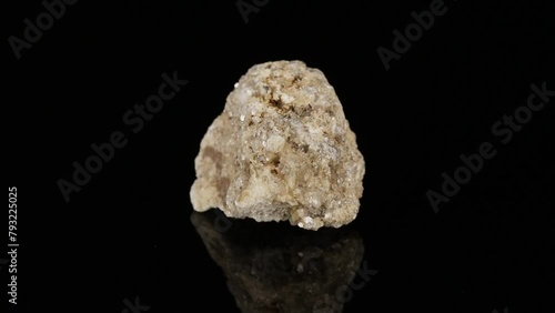 Polished mineral stone albite rotates in a circle on a black background photo