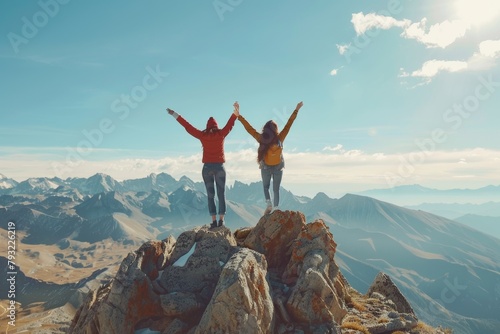 Happy couple celebrating success on mountain top with raised hands  joy and achievement in nature