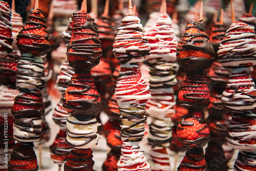 Close up, macro. Strawberries on skewers covered in chocolate. Barcelona market.