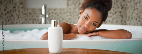 Relaxed woman enjoying a bubble bath, a moment of bliss. A serene young woman relaxing, her gaze calm and content, foregrounded by a bottle of luxury bath product, in a spa-like bathroom setting