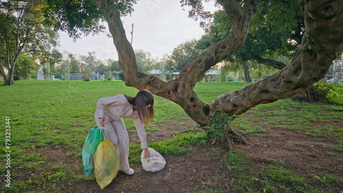 Conscious girl picking trash demonstrating environmental responsibility. 