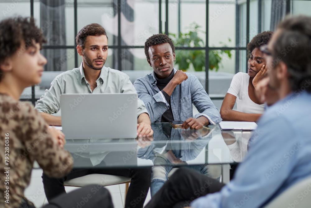 Employees working at computer together, discussing content Employees working at computer together, discussing content