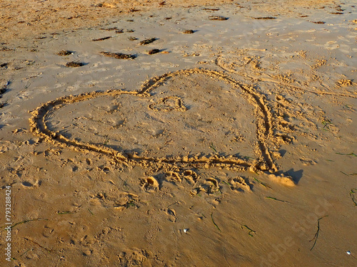 Cuore disegnato sulla sabbia in riva al mare 1414