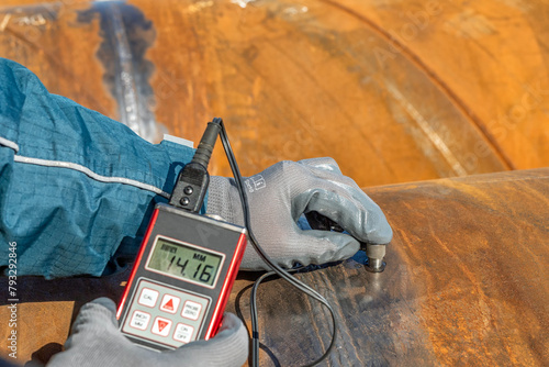 Technician is testing to pipe thickness with ultrasonic test method. Ultrasonic thickness measurement (UTM) is a method of performing non-destructive measurement (gauging) of the local thickness