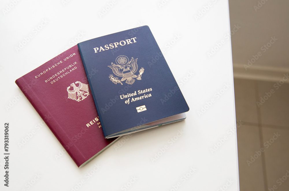 Close up of an American and German passports on white table Close up of an American and German passports on white table