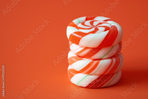 red and white peppermint candy stack on orange background