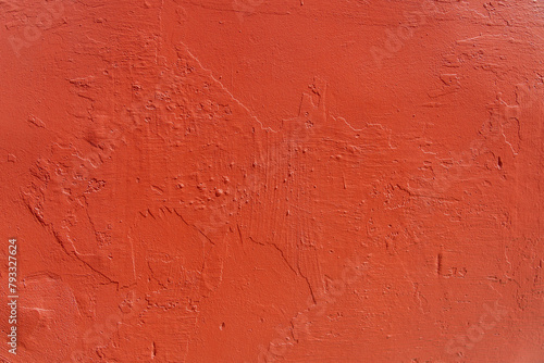 Detailed close-up of a rustic red wall with textured peeling paint suitable for backgrounds or layering in design projects.