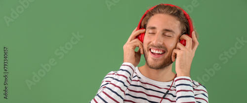 Handsome man listening to m...