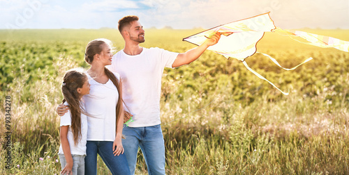 Happy family flying kite in...
