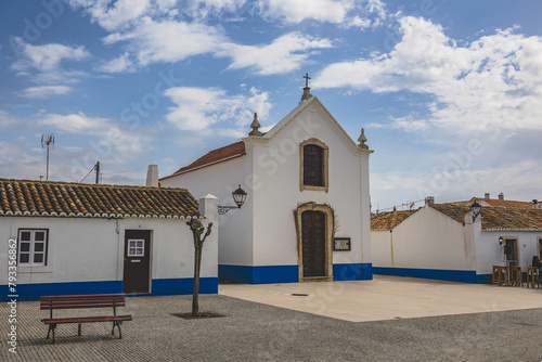 City of Porto Covo  with traditional Alentejo houses painted white with blue strip and red windows. Streets of the picturesque village of Porto Covo, located in the vicentine coast, Portugal. photo