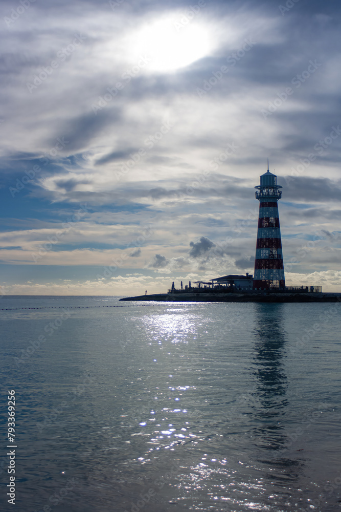 Vertical shot of a summer cloudy afternoon with a lighthouse in the background.Copy space. Banner for travel promotion