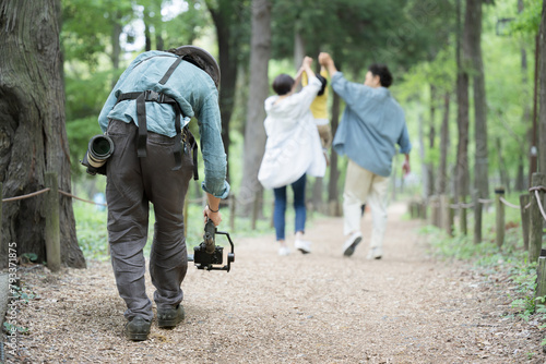 Photographer using a gimbal to capture a family walking in fresh greenery