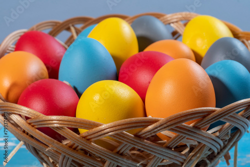 easter basket with straw and colored eggs