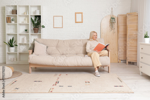 Mature woman reading magazi...