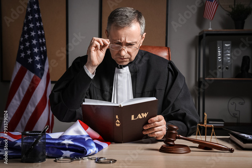 Mature judge reading law bo...