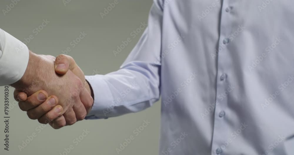 Handshake, agreement and partnership between business people. Closeup of two men handshaking after a successful deal, isolated on grey background Handshake, agreement and partnership between business people. Closeup of two men handshaking after a successful deal, isolated on grey background