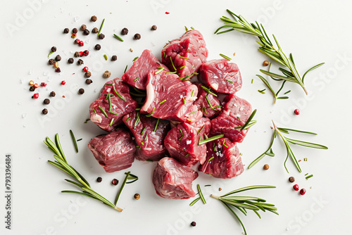 Heap of raw chopped beef with rosemary and peppercorns isolated on white background  photo