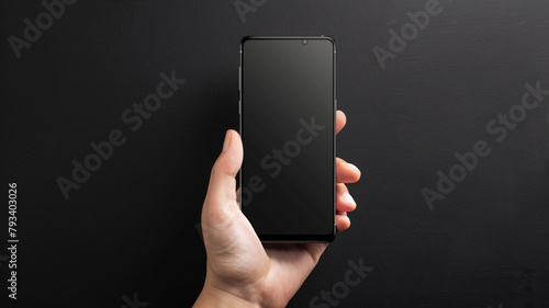 a hand display a smartphone screen mockup on black backdrop photo
