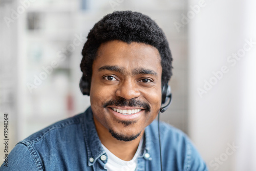 Friendly black guy with headset smiling at camera