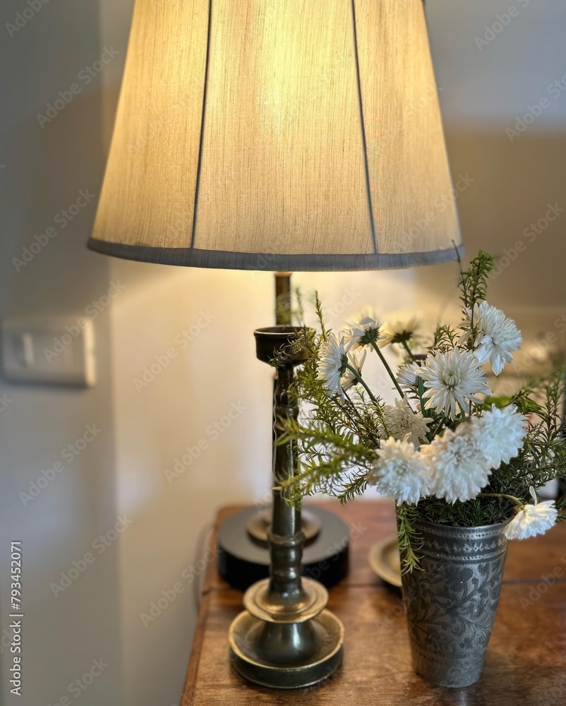 Table lamp and flower in vase on wooden table in living room Table lamp and flower in vase on wooden table in living room
