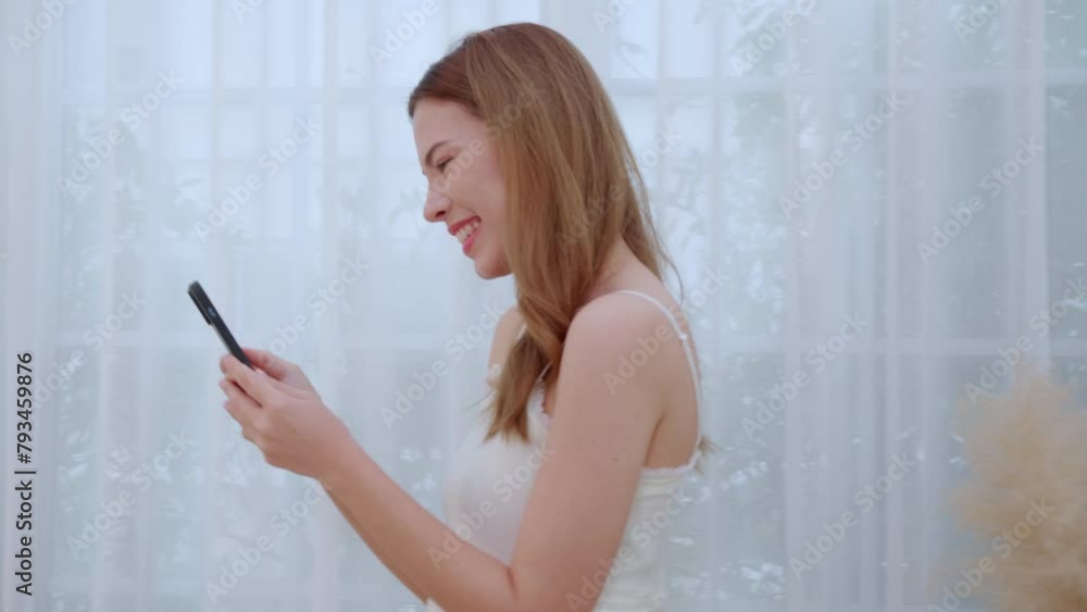 Young asian woman walking using smart phone for video call in living room at home, female using social media on phone for chat online and conversation distant with relax, lifestyle concept. Young asian woman walking using smart phone for video call in living room at home, female using social media on phone for chat online and conversation distant with relax, lifestyle concept.