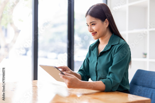 Portrait of Young asian business woman using tablet, standing in the office workplace.