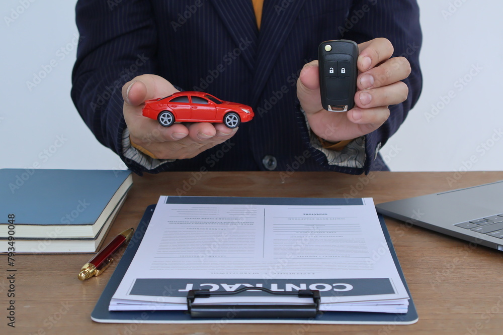 Fototapeta premium Businessman with car insurance documents. He is a male. Car insurance protects his vehicle. Documents are papers that show important information.