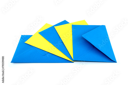 Blue and yellow paper envelopes arranged overt white