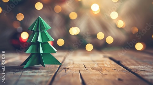Crafted green origami Christmas tree with warm bokeh lights on a rustic wooden tabletop, symbolizing homemade holiday spirit. photo