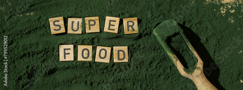 Wooden blocks with text SUPERFOOD chlorella on background of algae superfood powder. Healthy benefits supplement and vegan antioxidant healthy eating