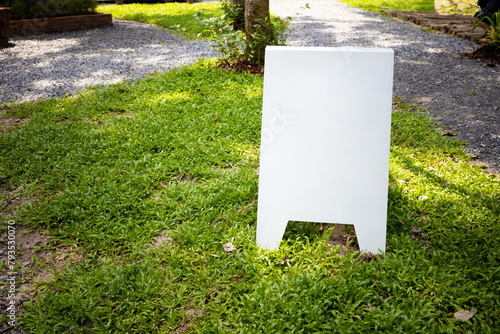 A white mock blank cafe menu stand on the grass yard