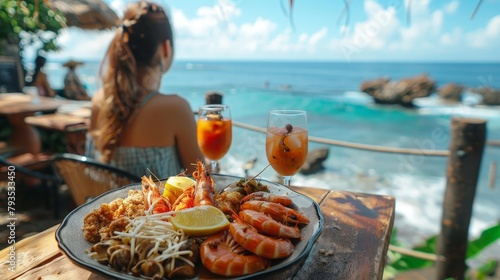 A woman is sitting at a table with a plate of seafood and a glasses of juice © BOONJUNG