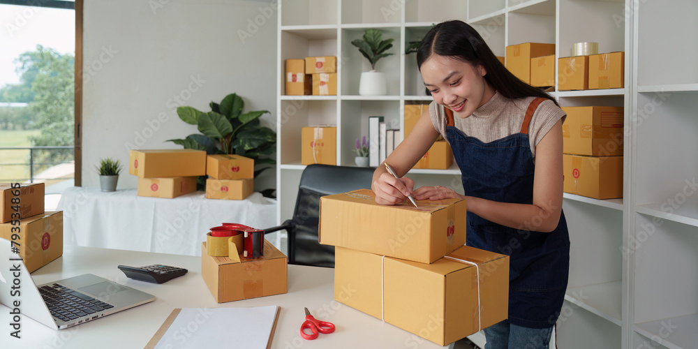 Fototapeta premium A woman entrepreneur working at home office and prepare a parcel before delivery