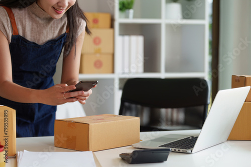 Close up woman entrepreneur working at home office and taking a parcel photo before delivery