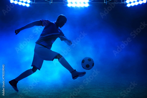 3d illustration shadow silhouette of young professional soccer player kicking ball in empty stadium at night