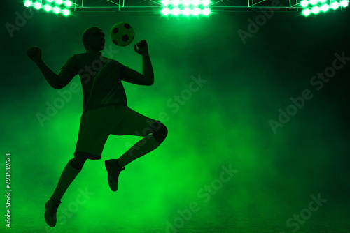 3d illustration shadow silhouette of young professional soccer player jumping in empty stadium at night © fotokitas