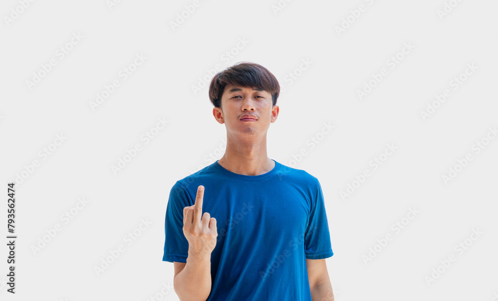 A young Asian man in his 20s wearing a blue t-shirt makes a gesture of showing your middle finger and scolding Fuck You isolated on a gray background