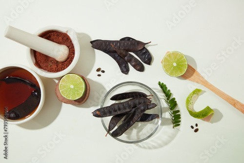 Ingredients for producing black locust pods products neatly arranged on white texture. Advertising photo with blank space for displaying product photo