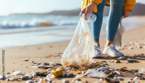 Eco-activism. Girl picks up plastic bottle and bag on beach. Nature, sea and waste. People and ecology. Environmental pollution. 